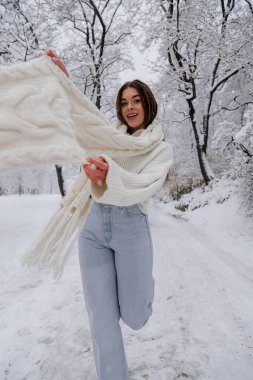 Kış tatili seyahati, Noel günü, Yeni Yıl, güzel mutlu kadın portresi karlı ormanlarda, doğa ormanlarında, kayak merkezlerinde, açık havada boş zaman aktivitelerinde, kar tanelerinin düşmesinden hoşlanan genç bayan, uzun atkılar. 