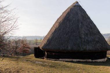 Kourim, Çek Cumhuriyeti, 17 Aralık 2023: Geleneksel köy ahşap ahşap ahır alçak duvarlar ve kışın dik sazdan çatı, tarihi kır tarzı mimari, açık hava etnoğrafya müzesi