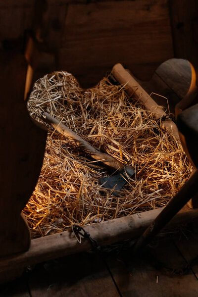 Kourim, Bohemia, Czech Republic, 17 December 2023: traditional Christmas Eve fortune-telling, Interior of house, country architecture, open air ethnographic museum, axe in hay under table