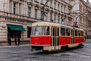 Prag, Çek Cumhuriyeti, 16 Aralık 2023: Çelenk ve ağaçlarla süslenmiş Noel Tramvayı, tarihi merkez caddesinde peri ışıkları, yeni yıl aydınlatmalı tramvay