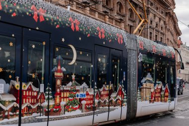 Prag, Çek Cumhuriyeti, 16 Aralık 2023: Çelenk ve ağaçlarla süslenmiş Noel Tramvayı, tarihi merkez caddesinde peri ışıkları, yeni yıl aydınlatmalı tramvay