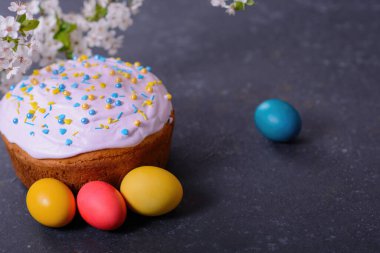 Taze pişmiş Paskalya ekmeği, doğal boyanmış yumurta ve bahar çiçekleri. Mutlu Paskalyalar. Şekerli ve şekerli paska, geleneksel bir Ukrayna çöreği..