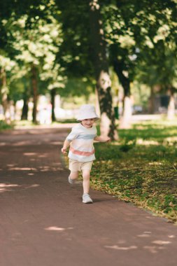 Panamalı mutlu bir çocuk ağaçların gölgesinde bir yaz parkında oynuyor..