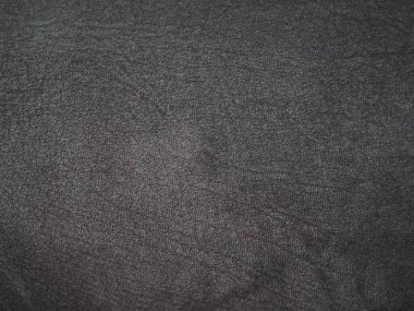 Yumuşak, bulanık yüzeyi ve ince dokunmuş desenleri olan koyu gri kumaş dokusuna yakın çekim. Tekstil, tasarım veya arkaplan kullanımı için ideal.