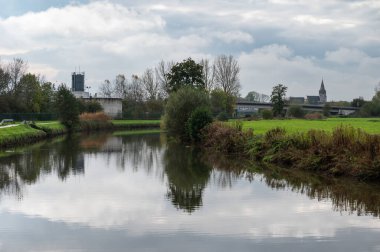 Liedekerke, Doğu Flaman Bölgesi, Belçika, 11 04 2022 - Dender Nehri 'ne yansıyan doğa ve sanayi