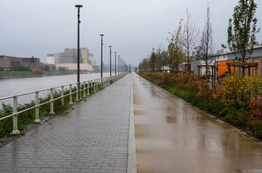 Neder-Over-Heembeek, Brüksel Başkent Bölgesi, Belçika - 11 19 2022 - Deniz kenarındaki bisiklet yolu - Scheldt Kanalı yağmurlu bir günde