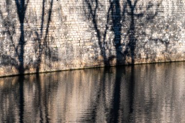 Nimes, Occitanie, France, 12 31 2022 - Abstract shadows against a brick stone wall of the canal