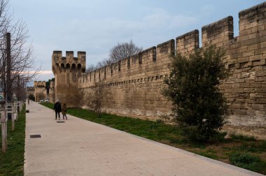 Avignon, Vaucluse, France, 12 29 2022 - Medieval defence wall at the borders of old town with a modern walking and pedestrian path