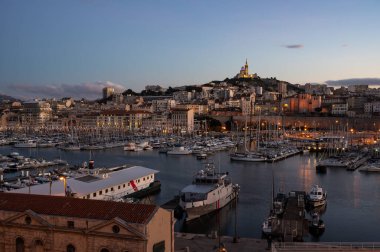 Marseille, Provence, France, 12 31 2022 - Night view over the old harbor with ships and historical monuments