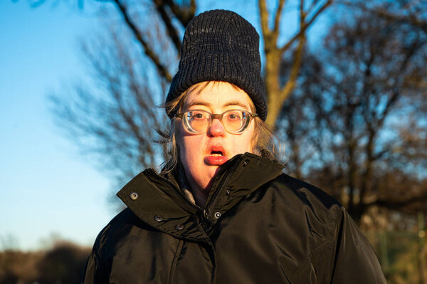 40 year old worried white woman with the Down Syndrome, wearing a hat and a winter jacket, Tienen, Flanders, Belgium