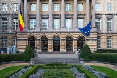 Brussels city center, Brussels Capital Region, Belgium - Jan. 19 2023 - Neo classical facade of the Federal Parliament with flags and a garden
