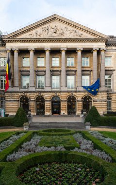 Brussels city center, Brussels Capital Region, Belgium - Jan. 19 2023 - Neo classical facade of the Federal Parliament with flags and a garden