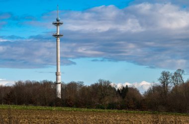 Ossel, Flemish Brabant Region, Belgium, Feb. 25 2023 - Broadcasting and telecommunication antenna in the fields against a blue sky