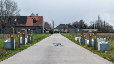 Merchtem, Flemish Brabant Region, Belgium, Feb. 25 2023 - Tractor speed bump in the middle of a countryroad