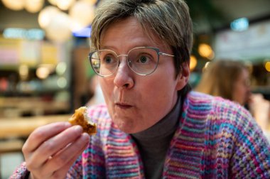 36 yaşında beyaz bir kadın içeride yemek yiyor, Brüksel, Belçika