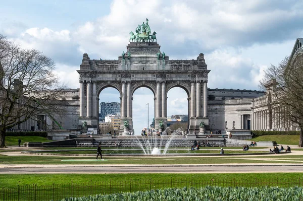 stock image Brussels European Quarter, Belgium - March 15, 2023 - The Triumphal arch at the Cinquentenaire park with green lawns and a fountain