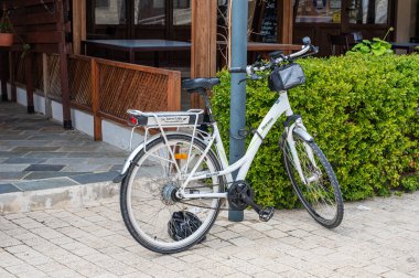 Tala, Paphos Bölgesi, Kıbrıs - 27 Mart 2023 - Restoran cephesinde duran beyaz elektrikli bisiklet