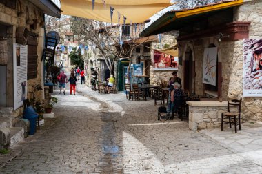Lofou, Limasol Bölgesi, Kıbrıs Rum Kesimi, 24 Mart 2023 - Köyde dükkanları ve restoran terasları olan geleneksel dar sokaklar