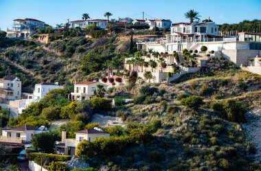 Peyia, Kıbrıs, 26 Mart 2023 - Tepelerdeki ve kayalıklardaki beyaz köy evleri