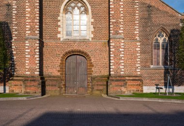 Tessenderlo, Limburg, Belçika - 21 Nisan 2023 - Kasaba pazar meydanındaki kilisenin ön cephesi ve girişi