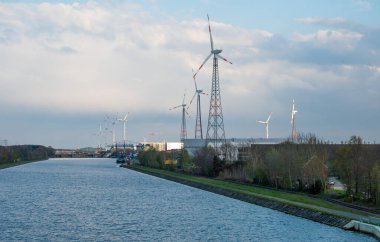 Meerhout, Belçika - 21 Nisan 2023 - Albert Kanalı 'nın kıyısındaki sanayi ve elektrik rüzgar değirmenlerine bakın