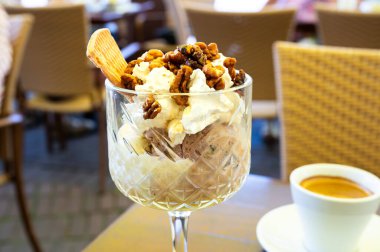 Ceviz, sos ve kremayla kaplı bir kase dondurma, bir fincan kahve, Kaldenkirchen, Almanya