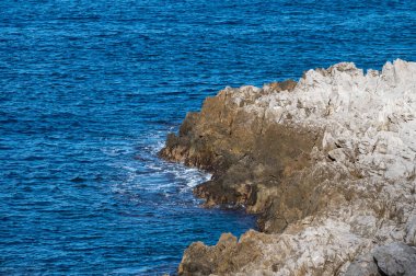 Capo Gallo, Sicilya, İtalya 'da mavi su ve engebeli kayalar