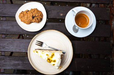 Yüksek açılı kurabiye, cheesecake ve bir fincan kahveyi ahşap bir masada, Brüksel, Belçika