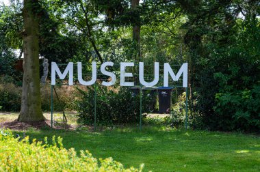 Heumen, Gelderland, The Netherlands, July 11, 2024 - Sign of a local museum with green surroundings clipart