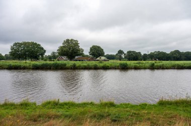 Markelo, Overijssel, Hollanda çevresinde bulutlu ve yağmurlu bir günde Twente Kanalı ve yeşil çevre