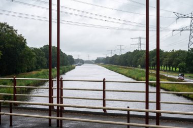 Goor, Overijssel, The Netherlands, July 12, 2024 - Bridge and high voltage electricity infrastructure over the Twente Canal clipart