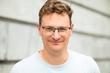 Brüksel, Belçika 'da gri bir duvara yaslanmış 45' lik beyaz bir adamın portresi. model bırakıldı