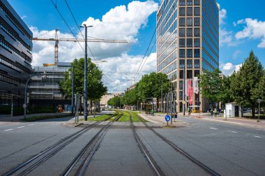Bremen, Almanya, 16 Temmuz 2024 - Tramvay rayları ve çağdaş iş binaları olan Eduard Shopf Allee