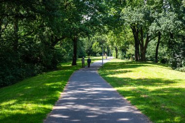 Bremen, Almanya, 16 Temmuz 2024 - Parkta yürüyen iki yaşlı vatandaş