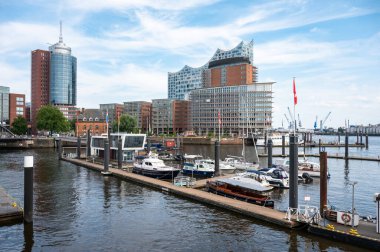 Hamburg, Almanya, 19 Temmuz 2024 - Jetty arka planda Elbphilharmonie konser salonu ile Hafencity limanında