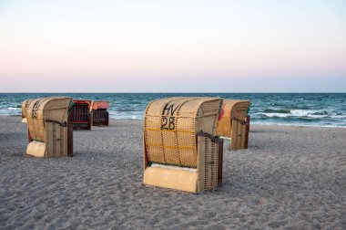 Dahme, Germany, July 20, 2024 - Sunset over the beach with beach baskets or Strandkorbe clipart