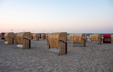 Dahme, Almanya, 20 Temmuz 2024 - Plaj sepetli gün batımı veya Strandkorbe