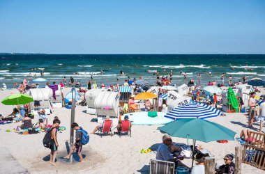 Scharbeutz, Ost Holstein, Almanya, 25 Temmuz 2024 - Tepeli plaj sandalyeli veya Strandkorbe