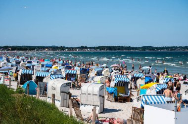Scharbeutz, Ost Holstein, Almanya, 25 Temmuz 2024 - Tepeli plaj sandalyeli veya Strandkorbe