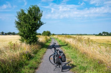 Rodby, Lolland, Danimarka 'da bisikletçiler için ıssız bir kırsal yolda bisikletle dolaşmak