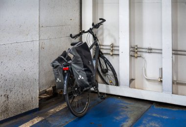 Fehmarn - Puttgarden, Germany, July 21, 2024 - Trekking bike standing in the bulk of a ferry ship clipart