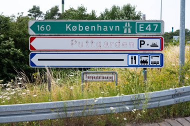 Rodbyhavn, Lolland, Denmark, July 21, 2024 - Traffic signs to the E47 to Copenhagen and the ferry to Puttgarden clipart