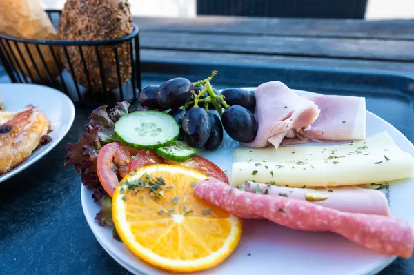 stock image Classic breakfast with bread buns, ham, cheese, fruits and sweet pastry,  Dahme, Holstein, Germany