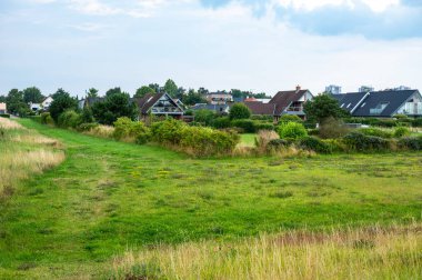 Green meadows and houses in the background at the brondby strandpark, Copenhagen, Denmark clipart