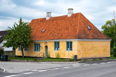 Storre Heddinge, Seeland, Danimarka, 23 Temmuz 2024 - Kırmızı kiremitli sarı geleneksel ev