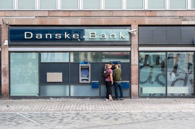 Kopenhag, Danimarka, 24 Temmuz 2024 - Danske Bankası 'nın ATM' sinde iki genç adam