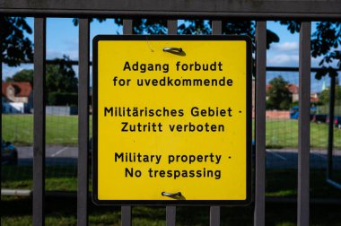 Copenhagen, Denmark, July 24, 2024 - Sign of Military property, trespassing prohibited in Danish, German and English clipart