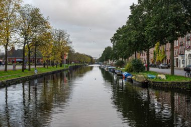 Amsterdam, Hollanda 'daki Tuinpark Nut en Genoegen bahçelerinin kanalında 14 Kasım 2024 sonbahar yansımaları.