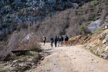 Arnavutluk 'taki Gamti Dağı' nda kirli çakıl yolda yürüyen bir grup turist, DEC 12, 2024