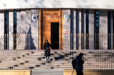 Young lady walking out of the orthodox Saint Paul's cathedral in Tirana, Albania, DEC 13, 2024 clipart